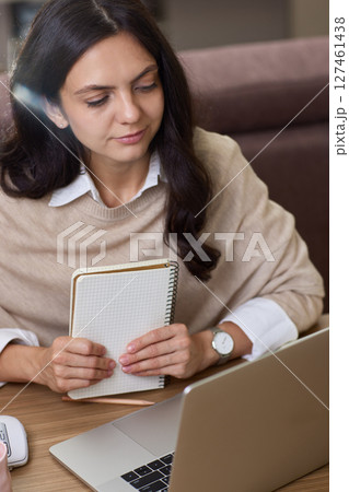 Beautiful woman in shirt using laptop while working at home 127461438
