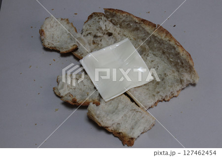 A broken baked baguette with melted cheese. 127462454