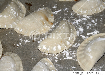 Close up of home made Chinese dim sum dumplings Jiaozi or Gyoza on bakking tray ready to be fried Close up of home made Chinese dim sum dumplings Jiaozi or Gyoza on bakking tray ready to be fried 127463319