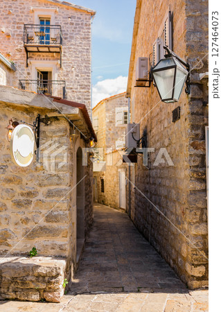 Narrow alleyway with stone walls and vintage lighting Summer travel, architectural charm, and the intimacy of historic European streets. 127464073