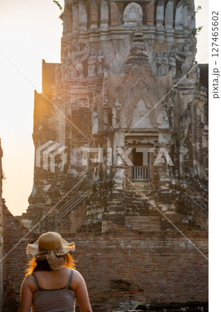 Rear view of young woman walking and exploring Ancient Ruins on holiday travel 127465602