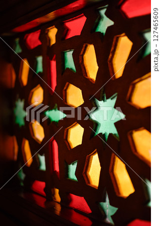 Window with Arabic colored lattice, soft curtain dropped on side and dim light 127465609