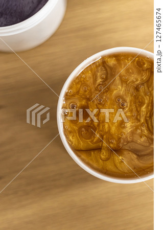 This creamy mixture is presented in a charming container with a vibrant purple lid This creamy mixture is presented in a charming container with a vibrant purple lid 127465674