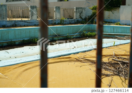 錆びた鉄格子越しに見える廃墟プール 錆びた鉄格子越しに見える廃墟プール 127466114
