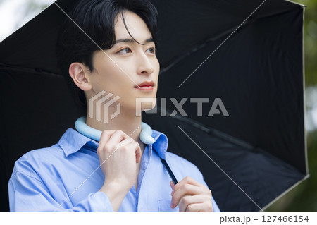 日傘を差す若い男性 127466154