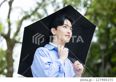 日傘を差す若い男性 127466155