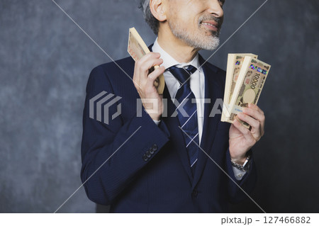 札束を持つ笑顔のシニアビジネスマン 127466882
