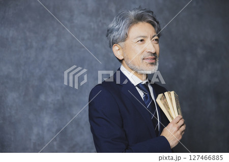 札束を持つ笑顔のシニアビジネスマン 127466885
