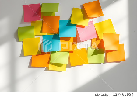 Colorful sticky notes on a white wall with natural light and shadows. Colorful sticky notes on a white wall with natural light and shadows. 127466954