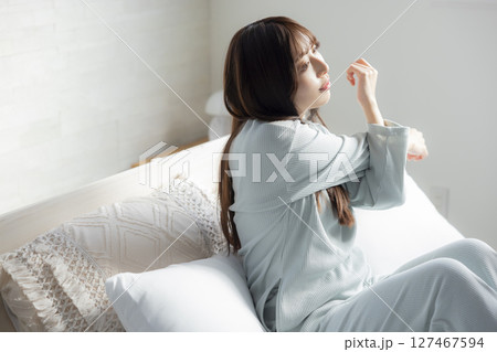 ベッドで伸びをする女性 127467594