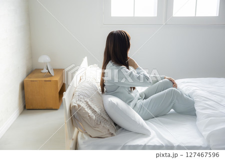 ベッドで伸びをする女性 127467596
