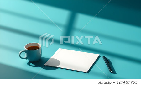 Minimalist setup with coffee, blank paper, and pen on a teal surface with window shadows. Minimalist setup with coffee, blank paper, and pen on a teal surface with window shadows. 127467753