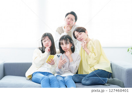 困った顔をしながらスマートフォンを使う親子 127468401