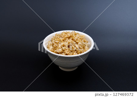 黒背景の茶碗によそう玄米ご飯 127469372