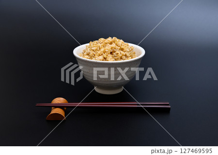 黒背景の茶碗によそう玄米ご飯 127469595