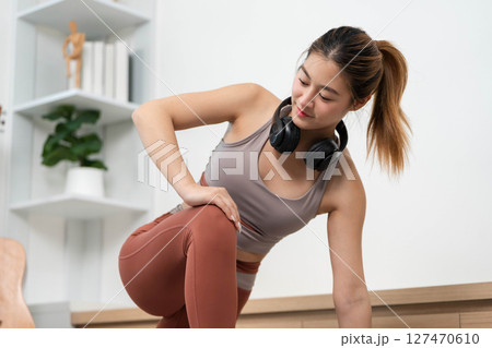 Yoga and Flexibility. Young woman practicing yoga stretch while seated at home. 127470610