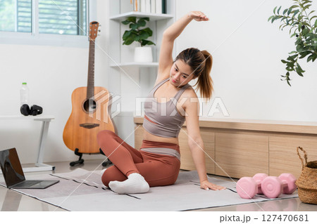 Yoga Stretch and Wellness. Woman stretching during yoga practice at home for health and relaxation. 127470681