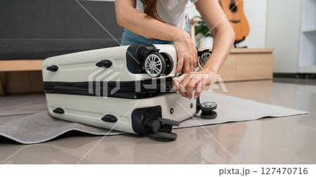 Travel Gear Maintenance. Woman fixing suitcase wheels at home. Travel Gear Maintenance. Woman fixing suitcase wheels at home. 127470716