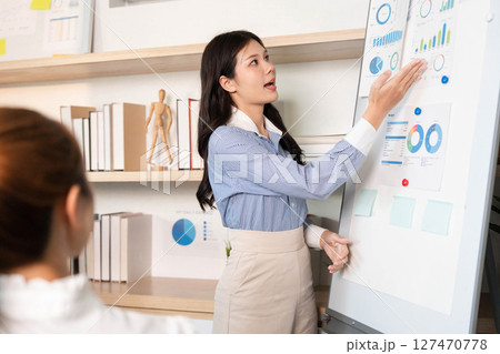 Business Presentation and Data Visualization. Professional woman explaining statistics in a meeting. 127470778