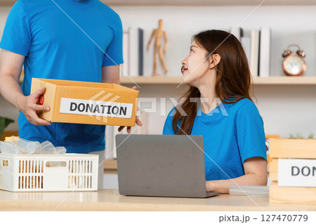 Donation in Action. A woman engaging in community support while receiving donations. Donation in Action. A woman engaging in community support while receiving donations. 127470779