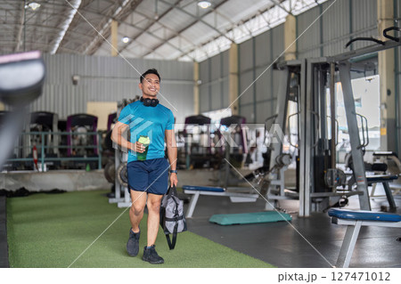 Fitness Journey: Man Smiling While Walking in Gym 127471012