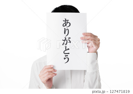 ありがとうと書かれた紙を両手で持つ人物 127471819