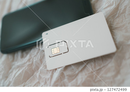 SIMカード台紙とスマホ SIMカード台紙とスマホ 127472499