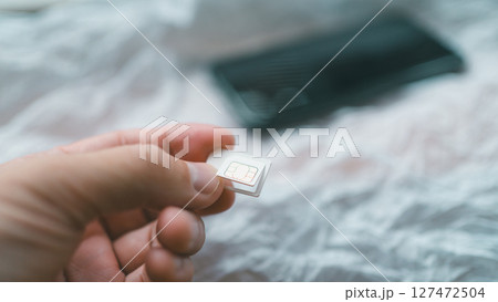 SIMカードを台紙から切り離す SIMカードを台紙から切り離す 127472504