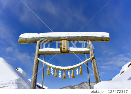 東北地方の大きな鳥居の上に雪が積もっている風景 127472537