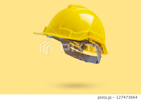 Safety construction helmet on yellow background 127473664