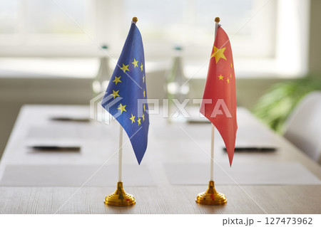 Flags of European Union and China on meeting table prepared for diplomatic negotiation or summit. 127473962