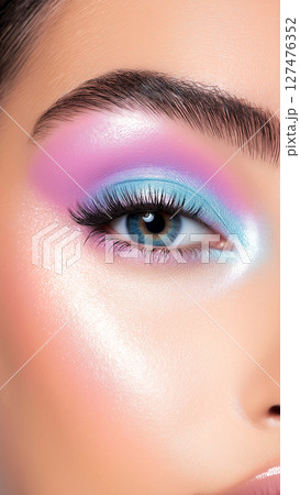 Close-up of a model's eye showcasing a vibrant, pastel unicorn-inspired makeup look with iridescent eyeshadow, long lashes, and a perfect eyebrow Close-up of a model's eye showcasing a vibrant, pastel unicorn-inspired makeup look with iridescent eyeshadow, long lashes, and a perfect eyebrow 127476352