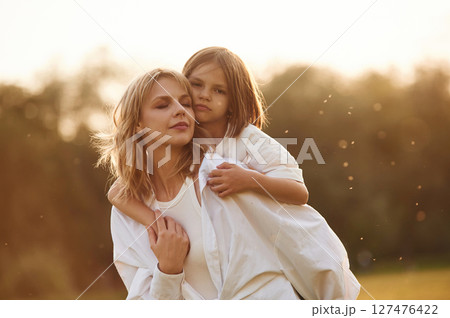 Conception of love, embracing each other. Woman with her little daughter are on the summer field together 127476422