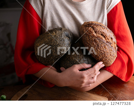 Woman hand hold fresh baked sourdough bread. Presenting Homemade ciabatta bread. 127477328