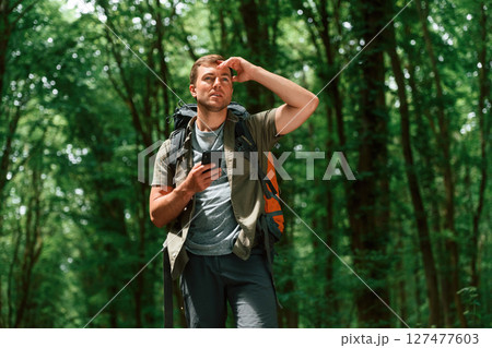 Searching the way, with smartphone for navigation. Tourist in summer forest. Conception of exploration and leisure 127477603