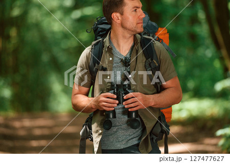 Navigation conception. With binoculars. Tourist in summer forest 127477627