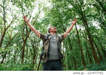 Enjoying the freedom, hands to the sides. Tourist in summer forest. Conception of exploration and leisure Enjoying the freedom, hands to the sides. Tourist in summer forest. Conception of exploration and leisure 127477702