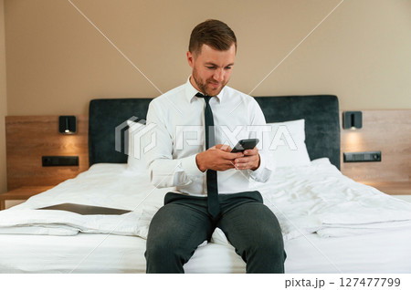 Businessman is indoors in the hotel room Businessman is indoors in the hotel room 127477799