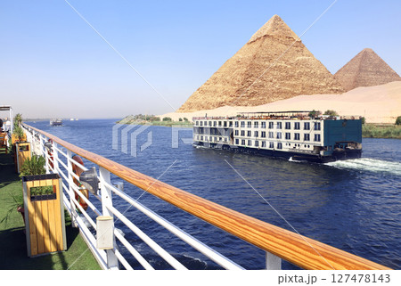 Great Pyramids of Chephren and Cheops and cruise ship on the Nile river, Egypt, Africa. Famous tourist attraction. Topic of travel, trip abroad on vacation, cruises and tours 127478143