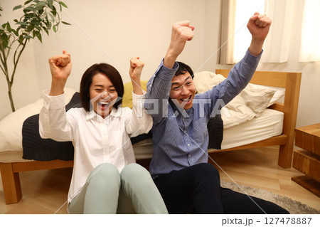 テレビを見て喜ぶ夫婦 テレビを見て喜ぶ夫婦 127478887