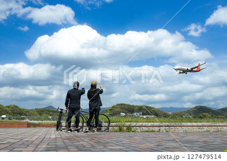 着陸する飛行機を眺める二人 着陸する飛行機を眺める二人 127479514