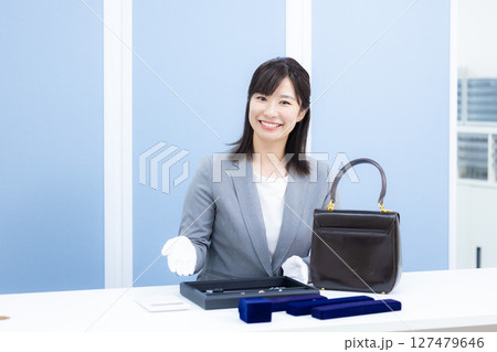 買取業者 窓口で査定をしている女性 買取業者 窓口で査定をしている女性 127479646