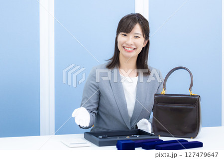 買取業者　窓口で査定をしている女性 127479647