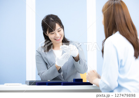 買取業者　窓口で査定をしている女性 127479898