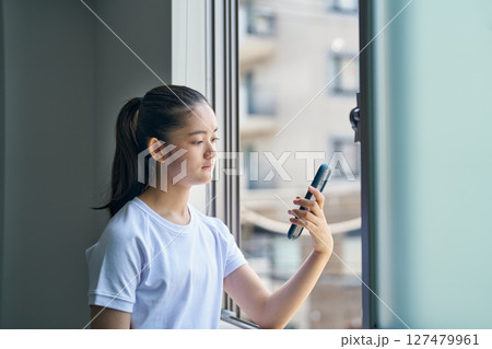体育の授業中、スマホを眺める少女 127479961