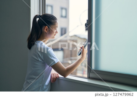 体育の授業中、スマホを眺める少女 127479962