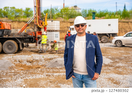 Supervisor overseeing soil sampling and pile drilling process on construction site. Responsible specialist ensuring quality control and compliance during geotechnical operations 127480302