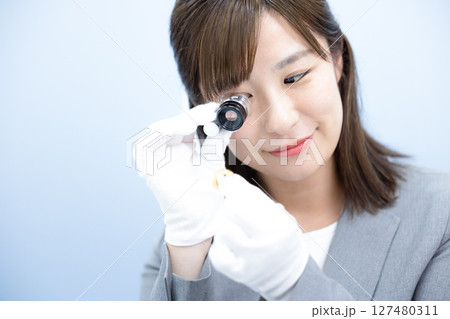 買取業者　窓口で査定をしている女性 127480311