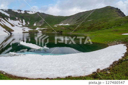Glacial lake in low clouds in changeable weather 127480547