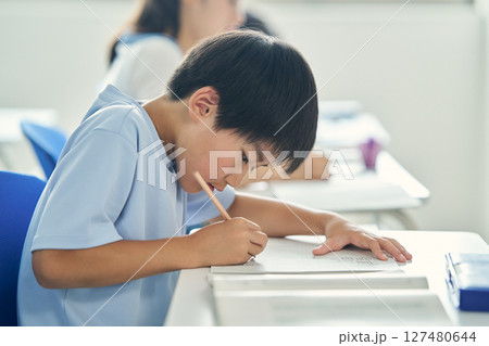 懸命に勉強する少年 127480644